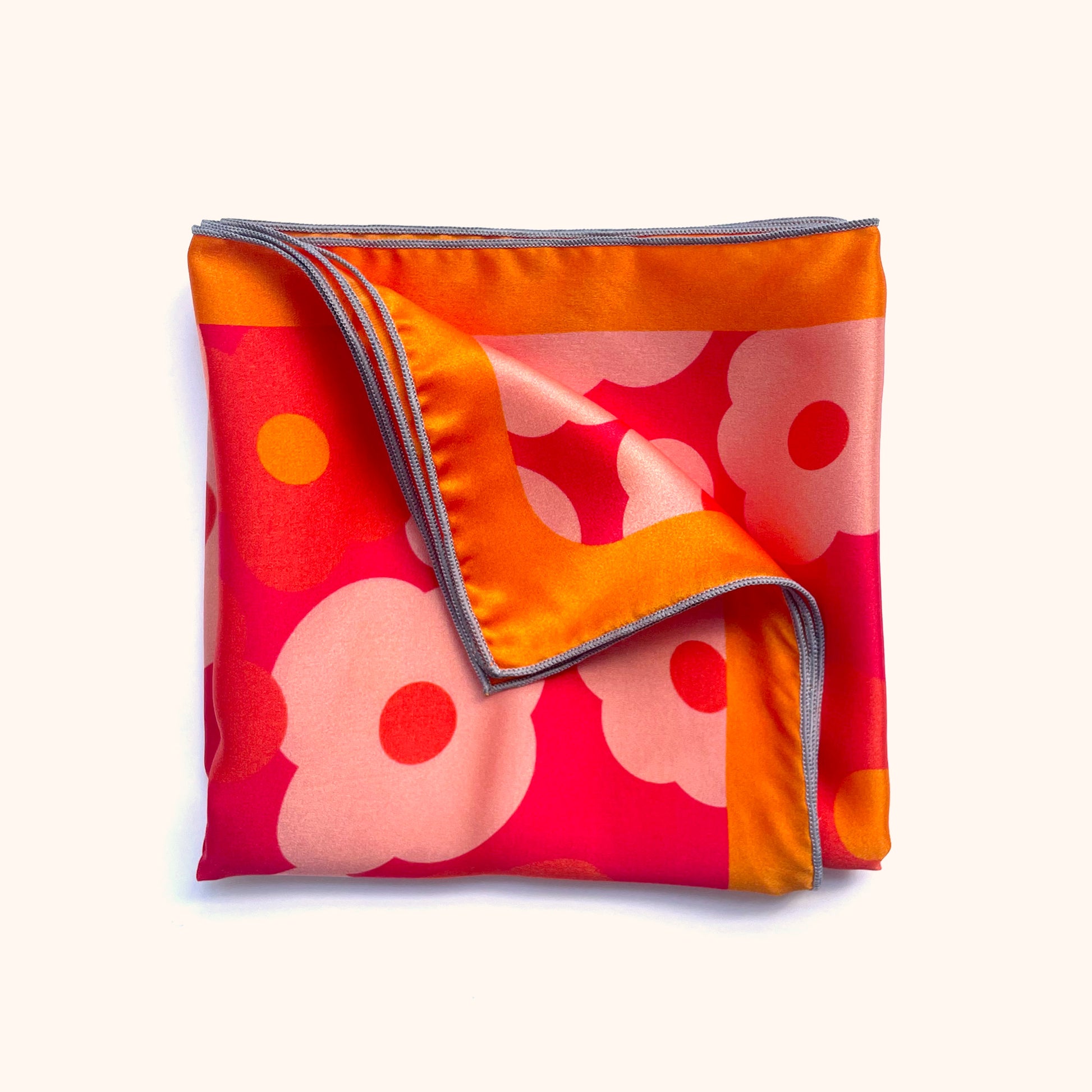 A pink, red, and orange floral print silk scarf that feels like spring year round.