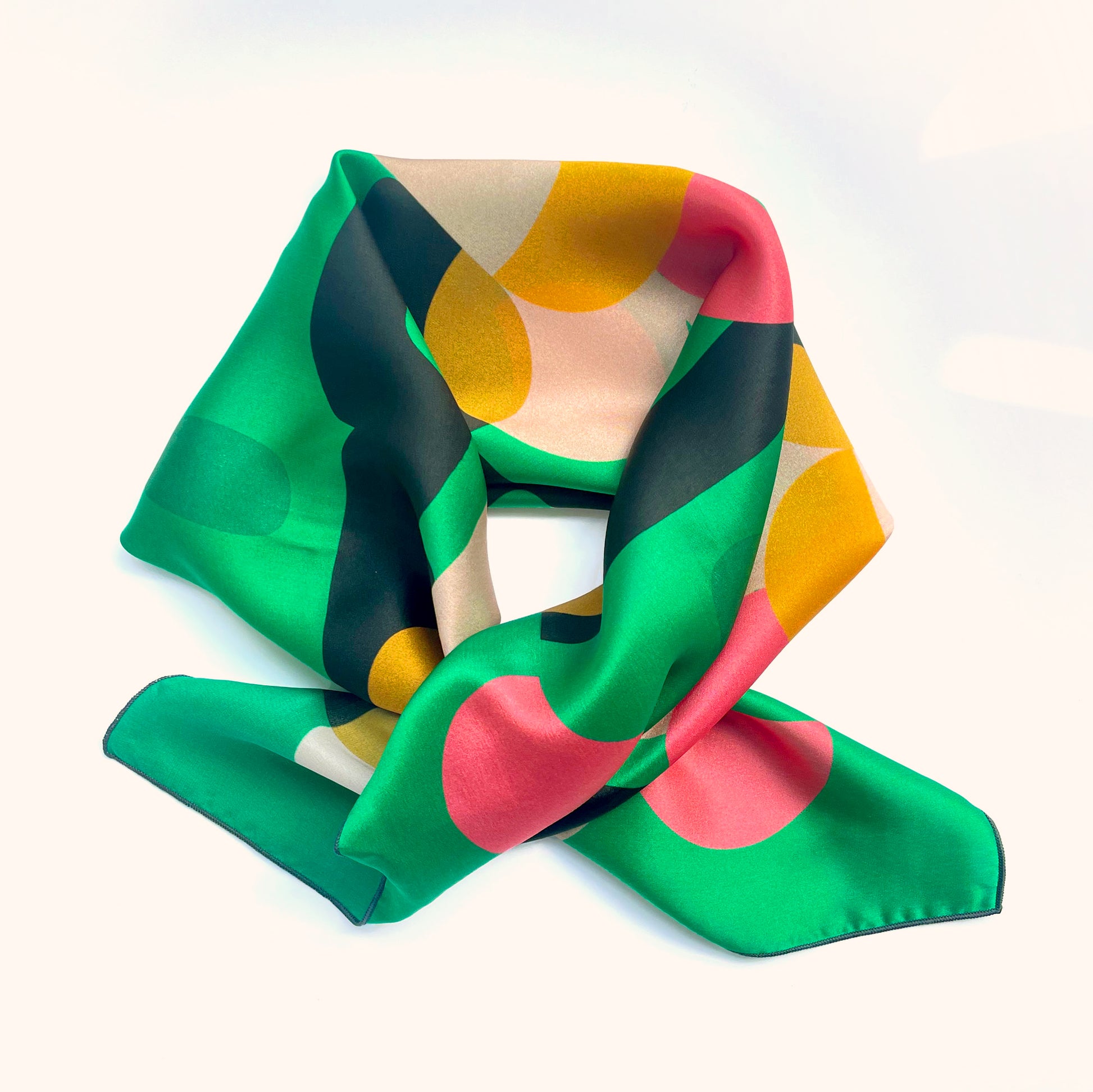This 1960s inspired design in green, pink, black and cream is a square silk scarf that's mood enhancer and compliment getter
