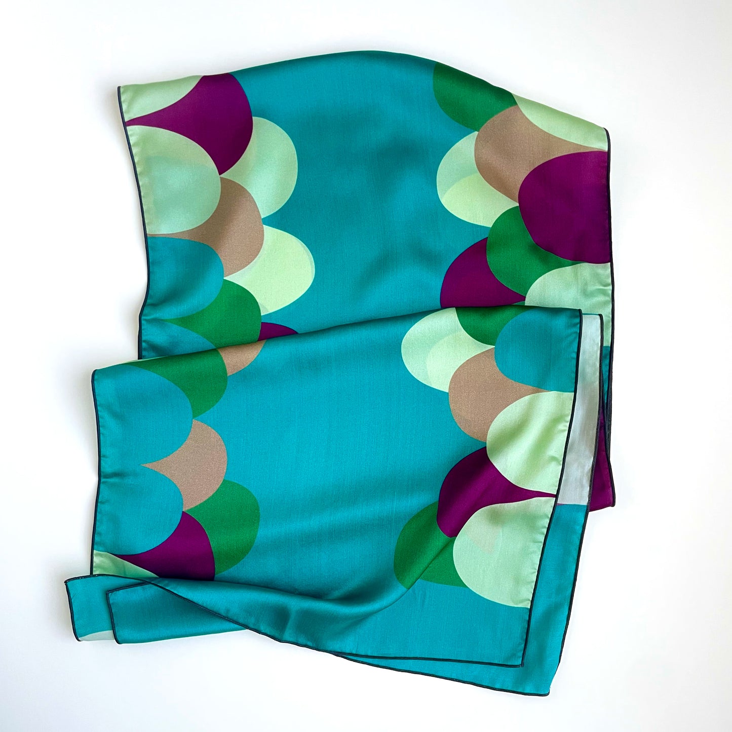 Organic retro shapes in jewel tones of purple, green, cream, and teal are a vibrant way to boost your mood with this luxurious long silk charmeuse scarf 