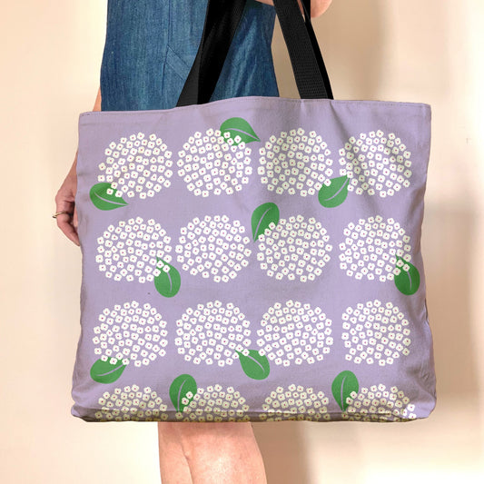 Lavendar oversized tote with cheerful hydrangea design. Cotton canvas bag is fully lined with zippered pockets and magnetic closure