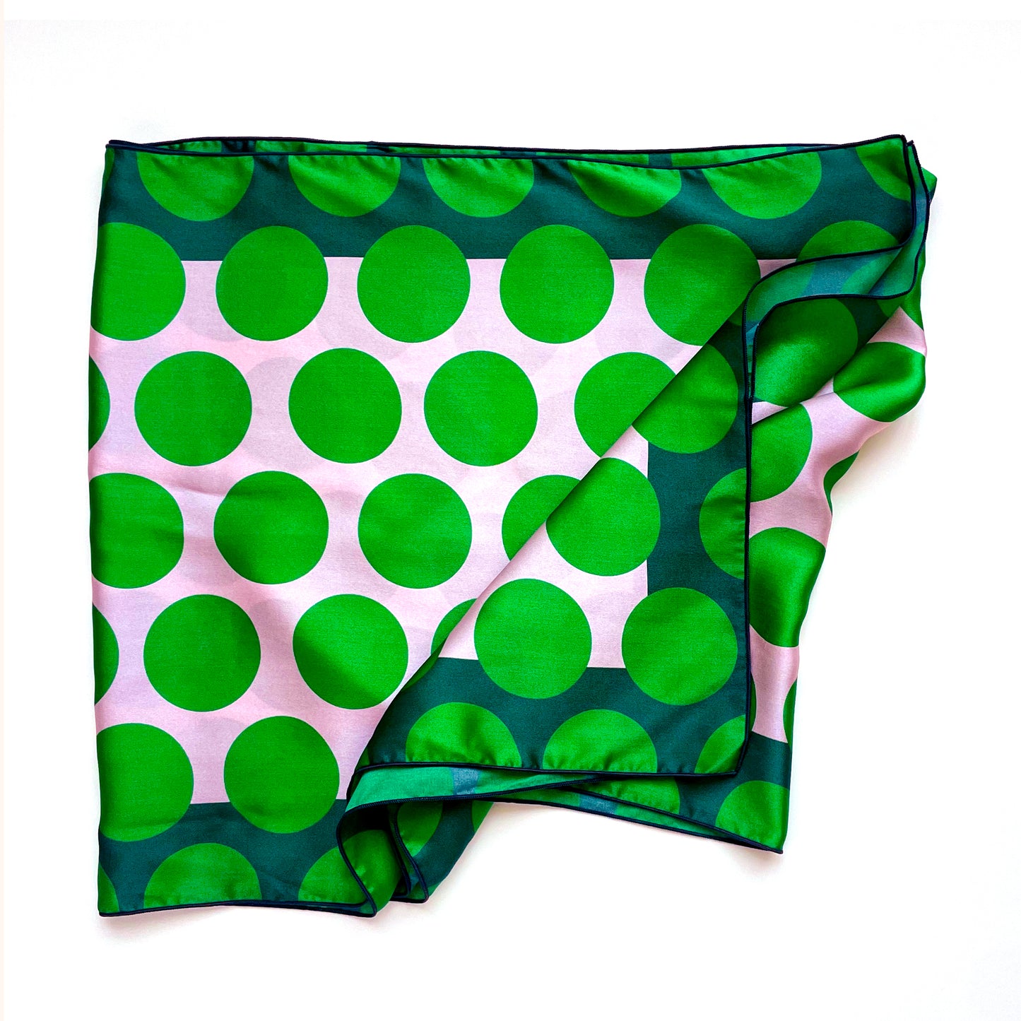 Large green polka dot print on this long silk scarf is a cheerful way to brighten your day and your outfit.