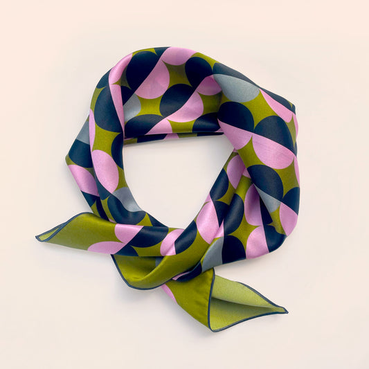 100% silk olive green silk scarf with a pink and black geometric pattern, guaranteed to turn heads with its retro style. Try as a hair scarf or neckerchief.