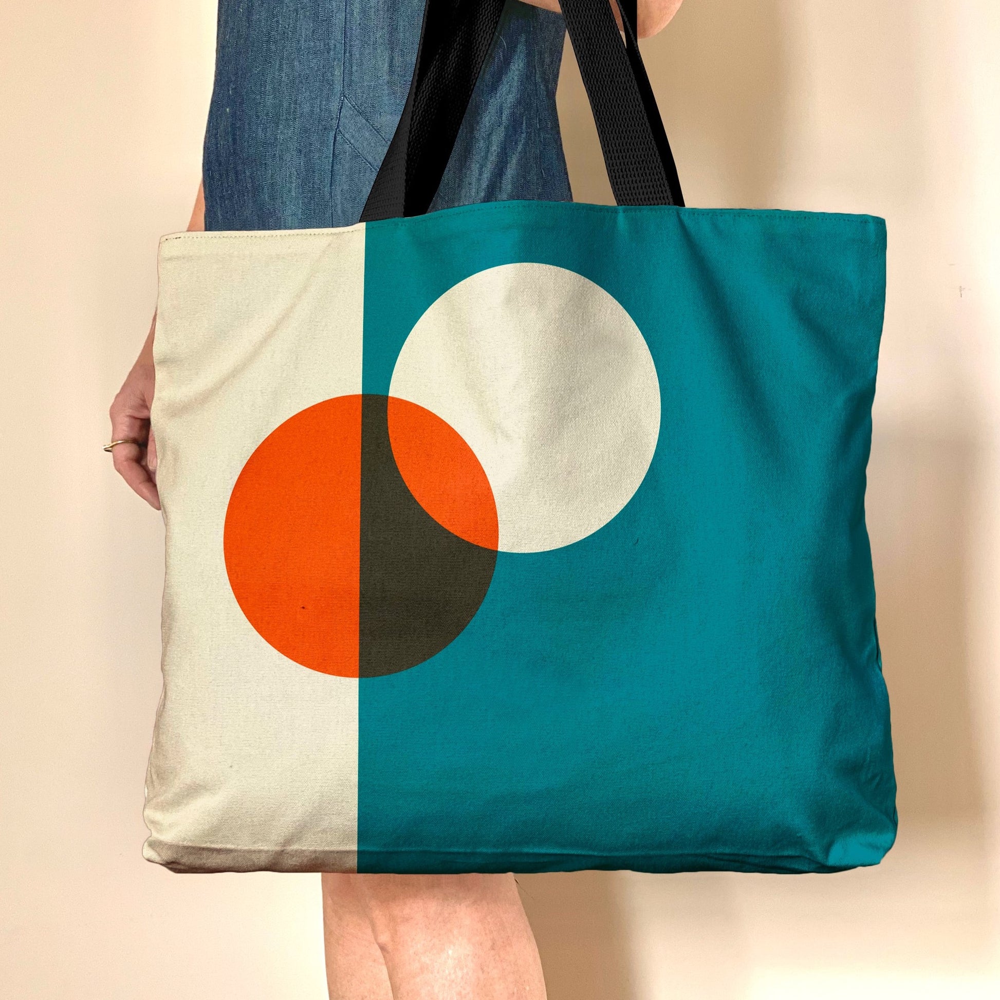 Bauhaus inspired oversized cotton canvas tote  with geometric orange and white circles on a blue background.